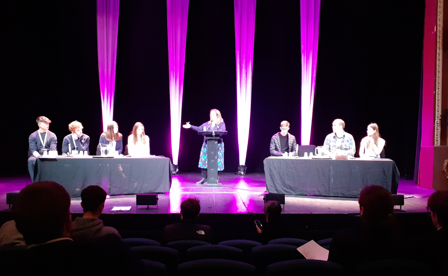 Students debating on a stage